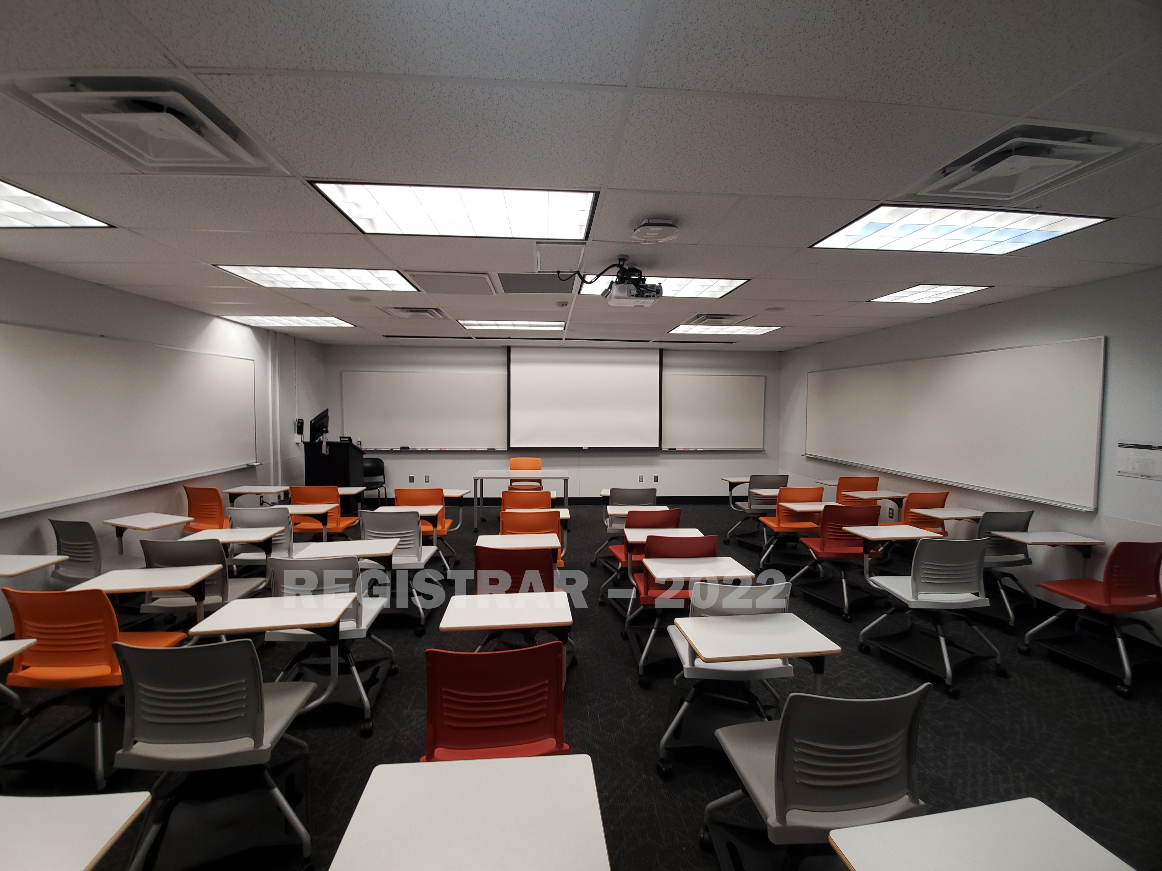Journalism Building room 274 ultra wide angle view from the back of the room with projector screen down