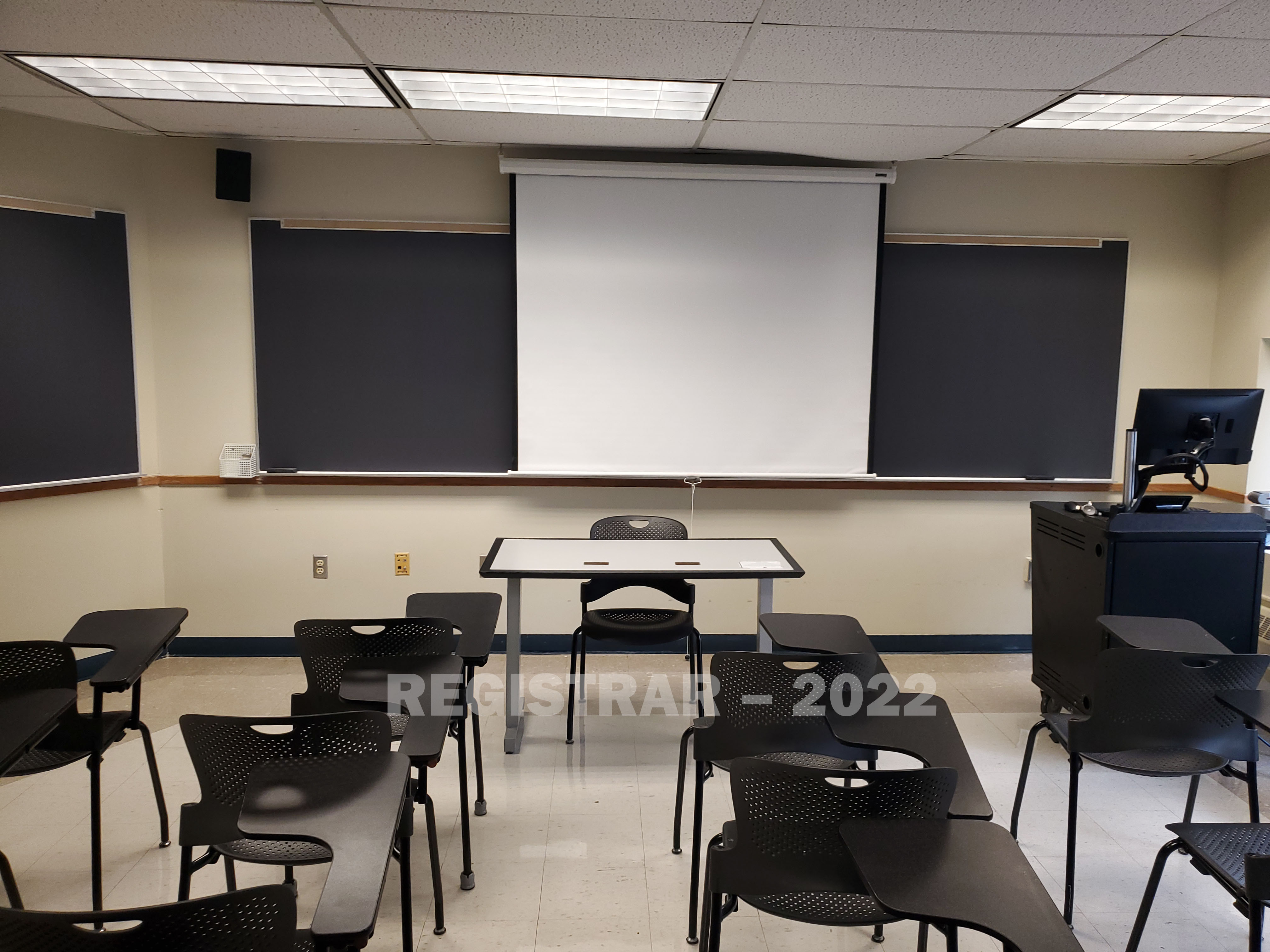 Enarson Classroom Building room 218 view from the back of the room with projector screen down