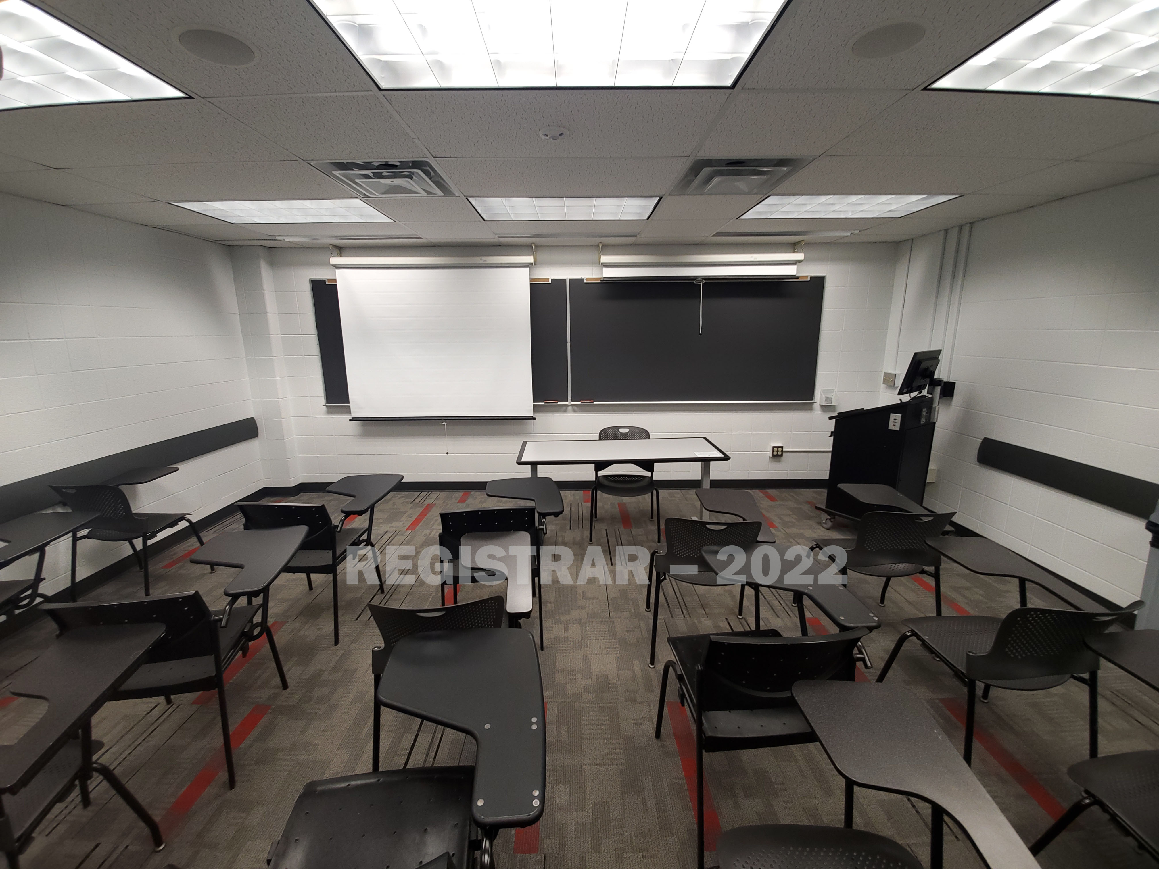 University Hall room 74 ultra wide angle view from the back of the room with projector screen down