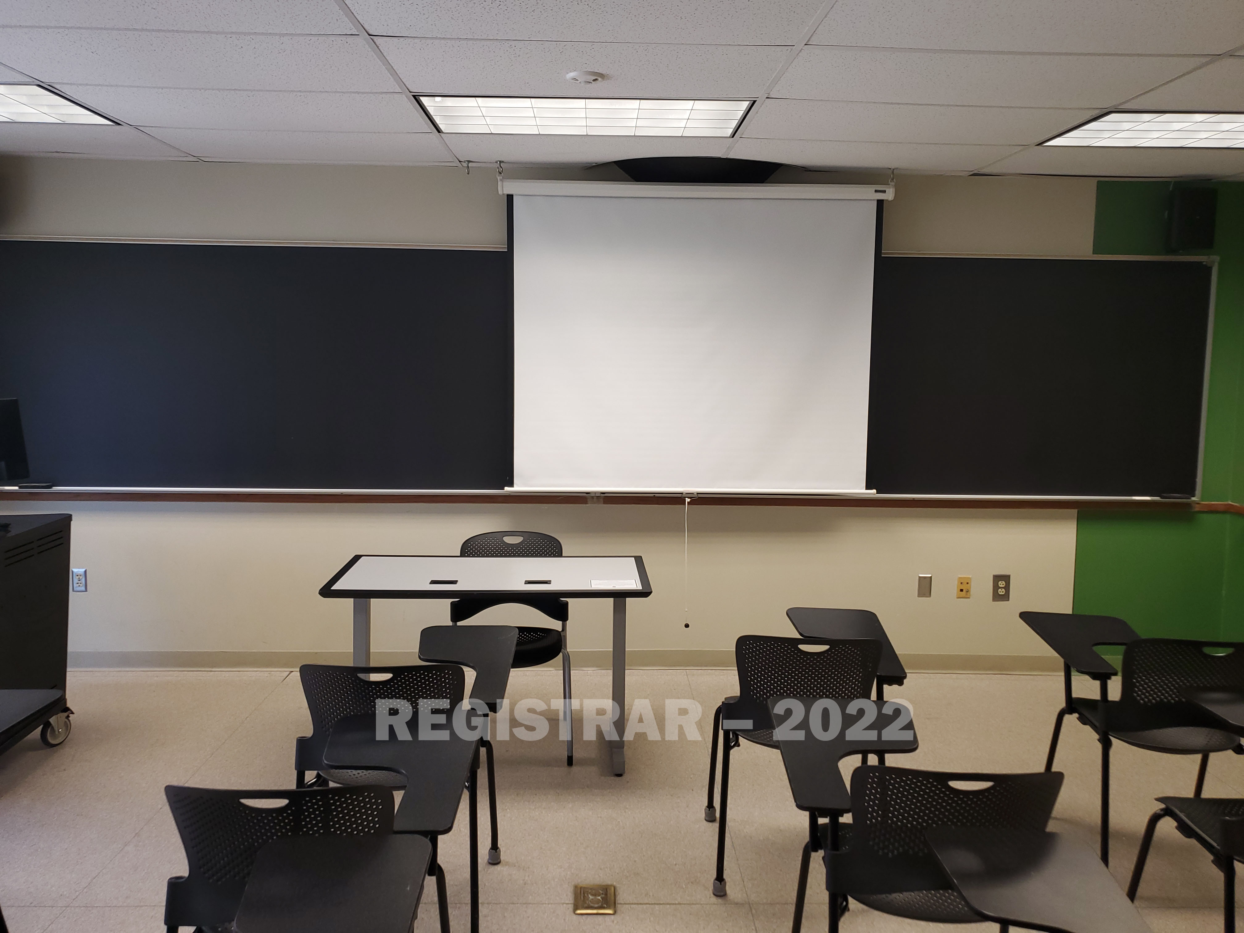 Enarson Classroom Building room 304 view from the back of the room with projector screen down