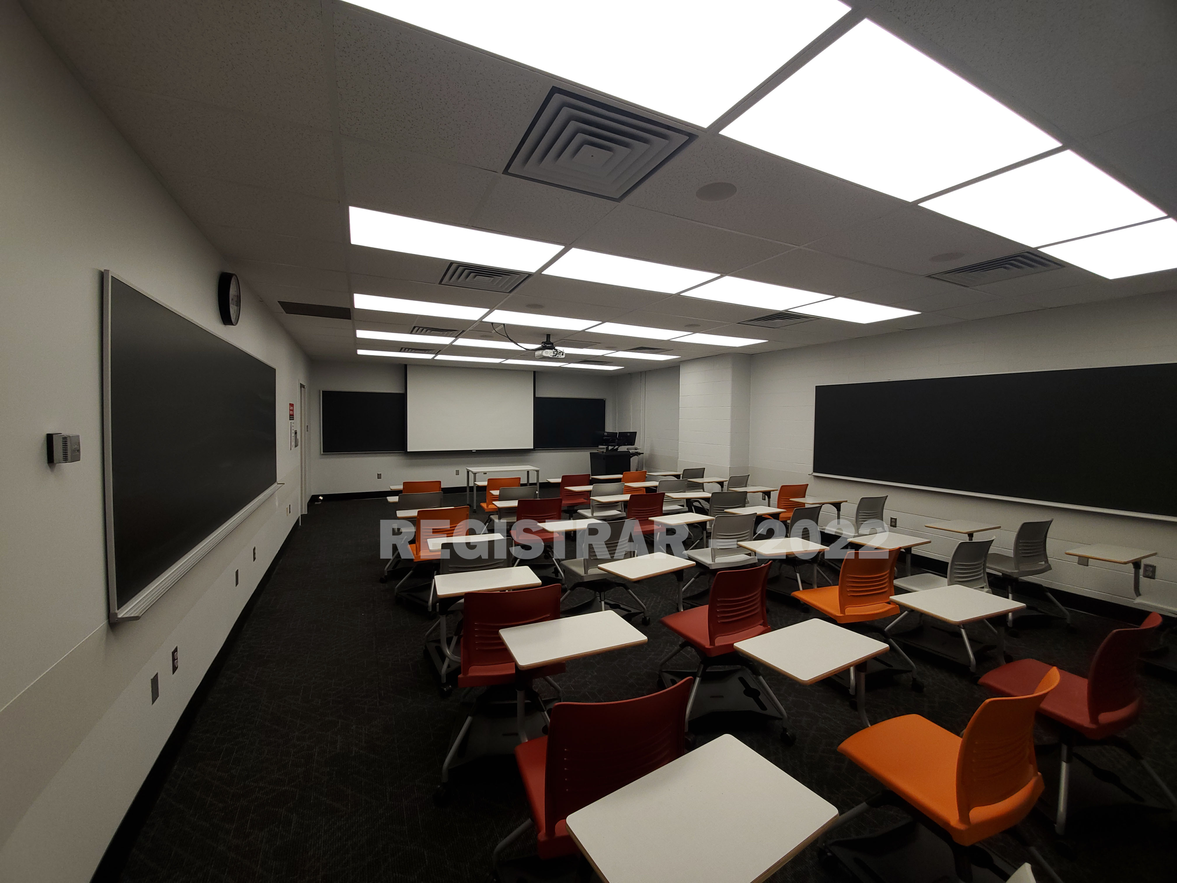 Journalism Building room 353 ultra wide angle view from the back of the room with projector screen down