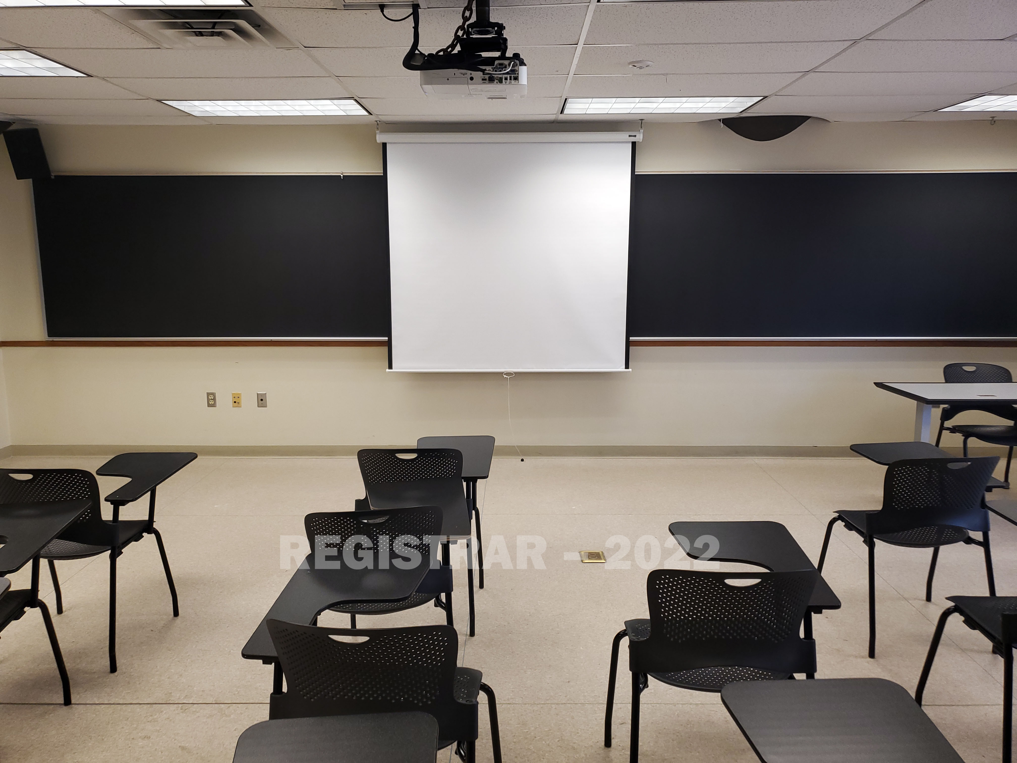 Enarson Classroom Building room 326 view from the back of the room with projector screen down