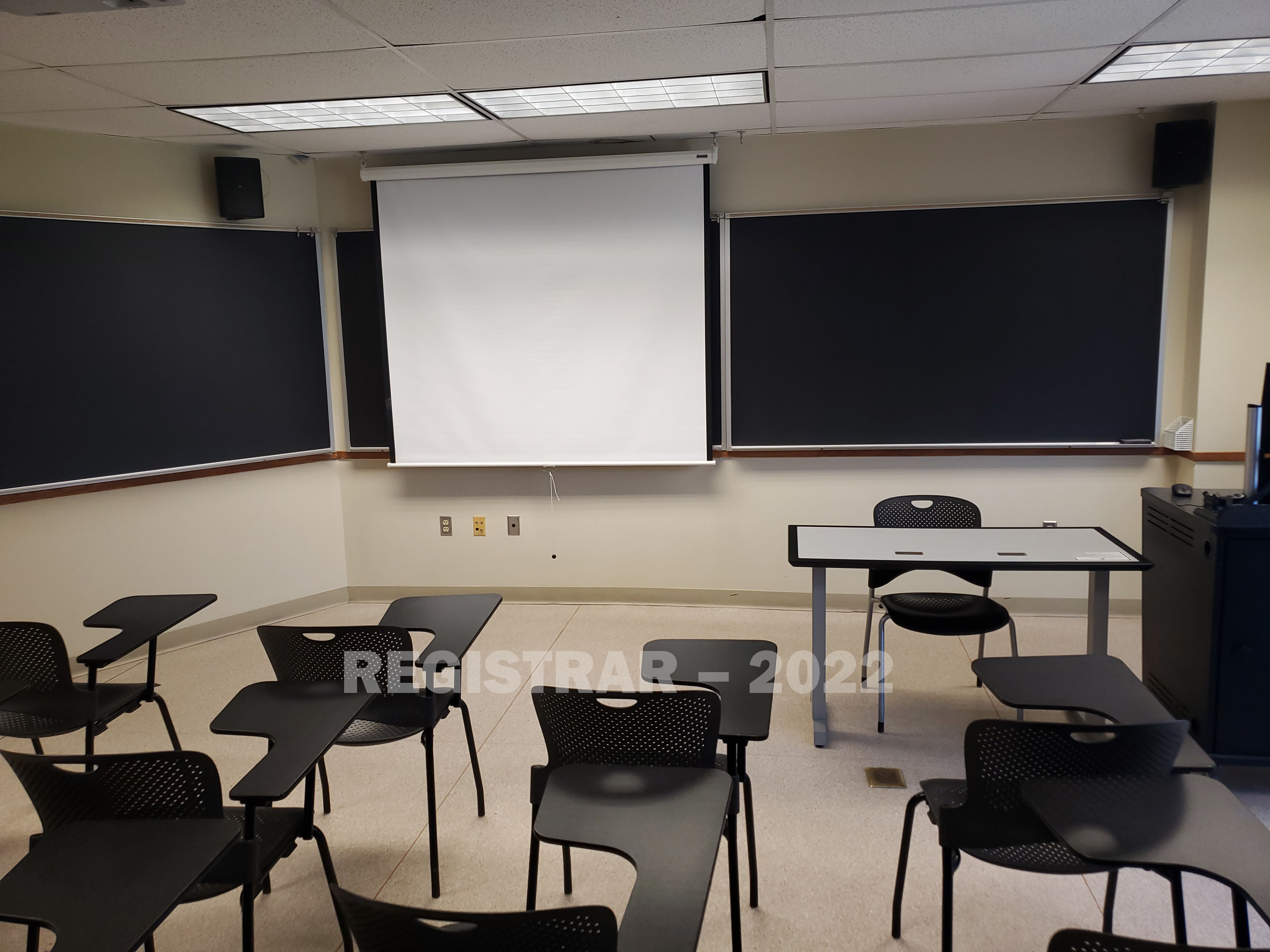Enarson Classroom Building room 318 view from the back of the room with projector screen down