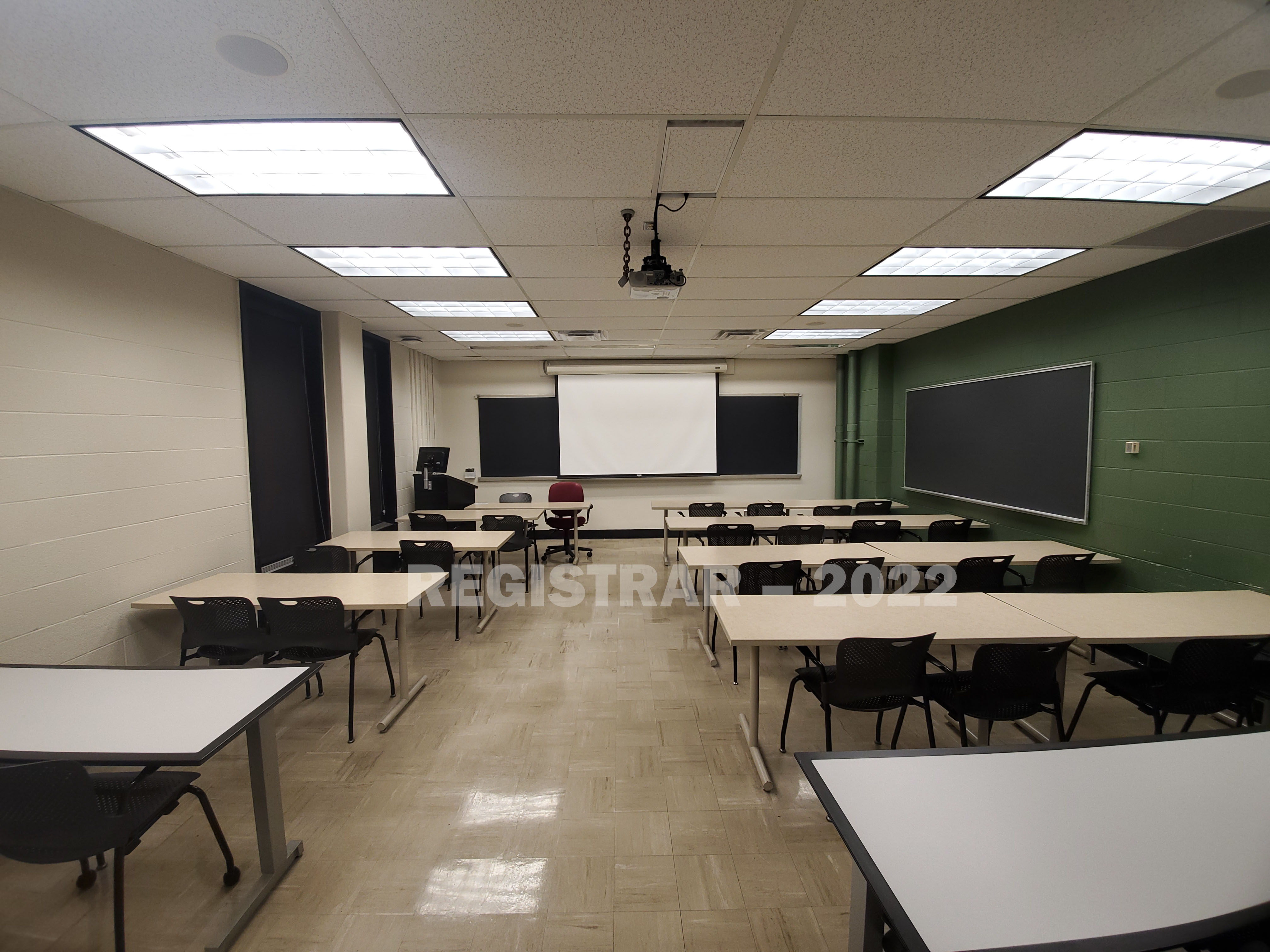 Baker Systems Engineering room 394 ultra wide angle view from the back of the room with projector screen down