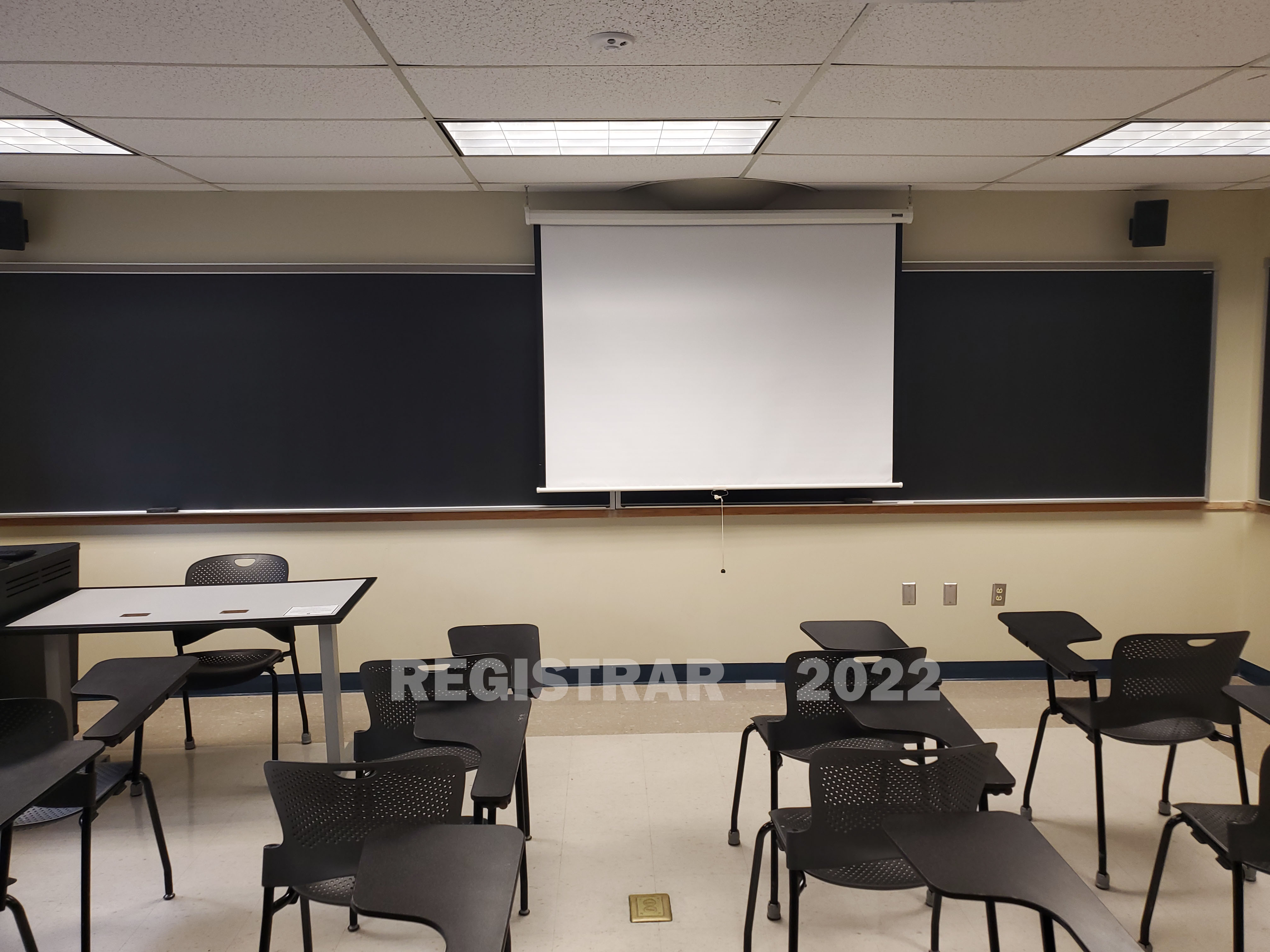 Enarson Classroom Building room 212 view from the back of the room with projector screen down