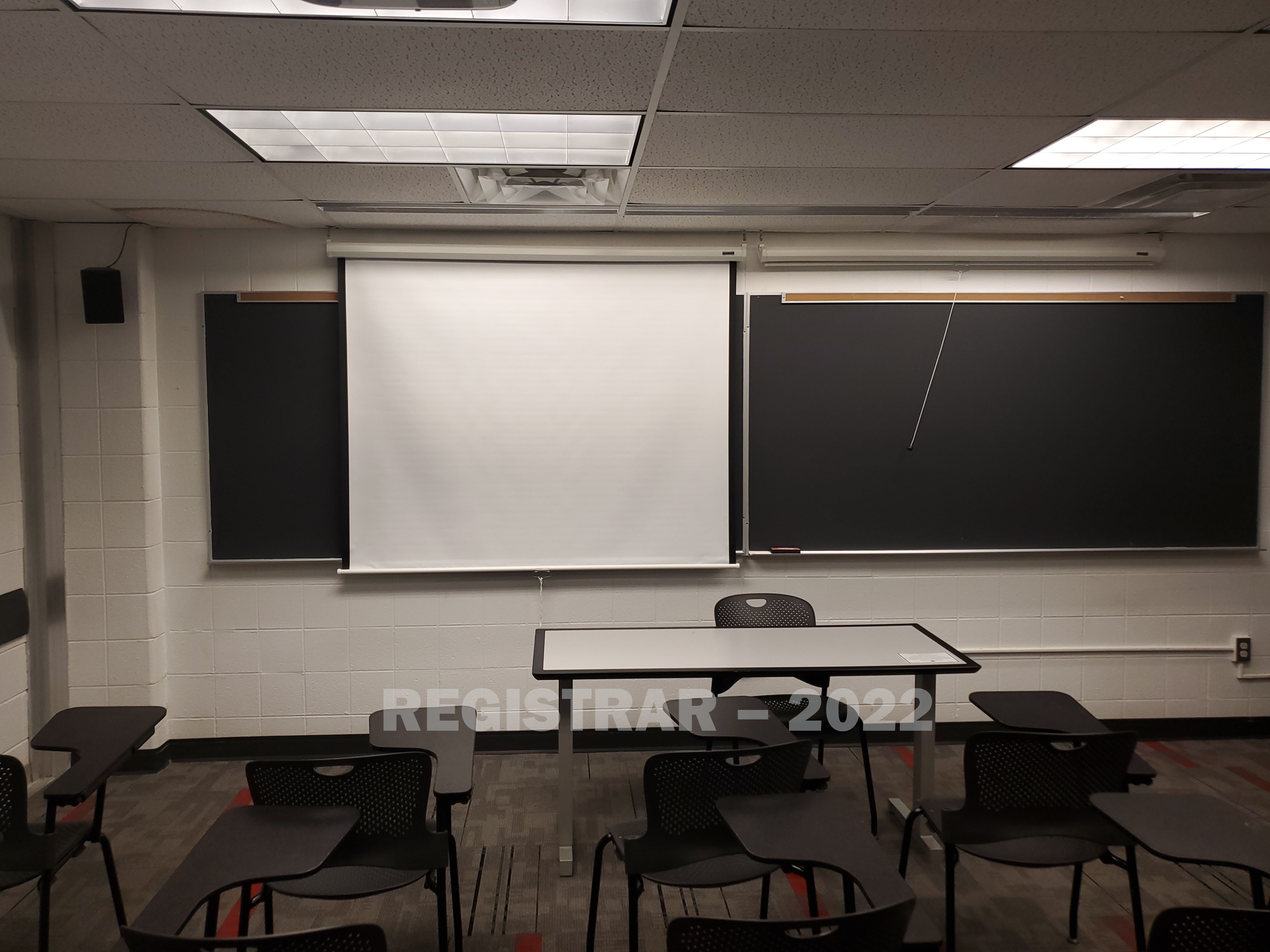 University Hall room 28 view from the back of the room with projector screen down