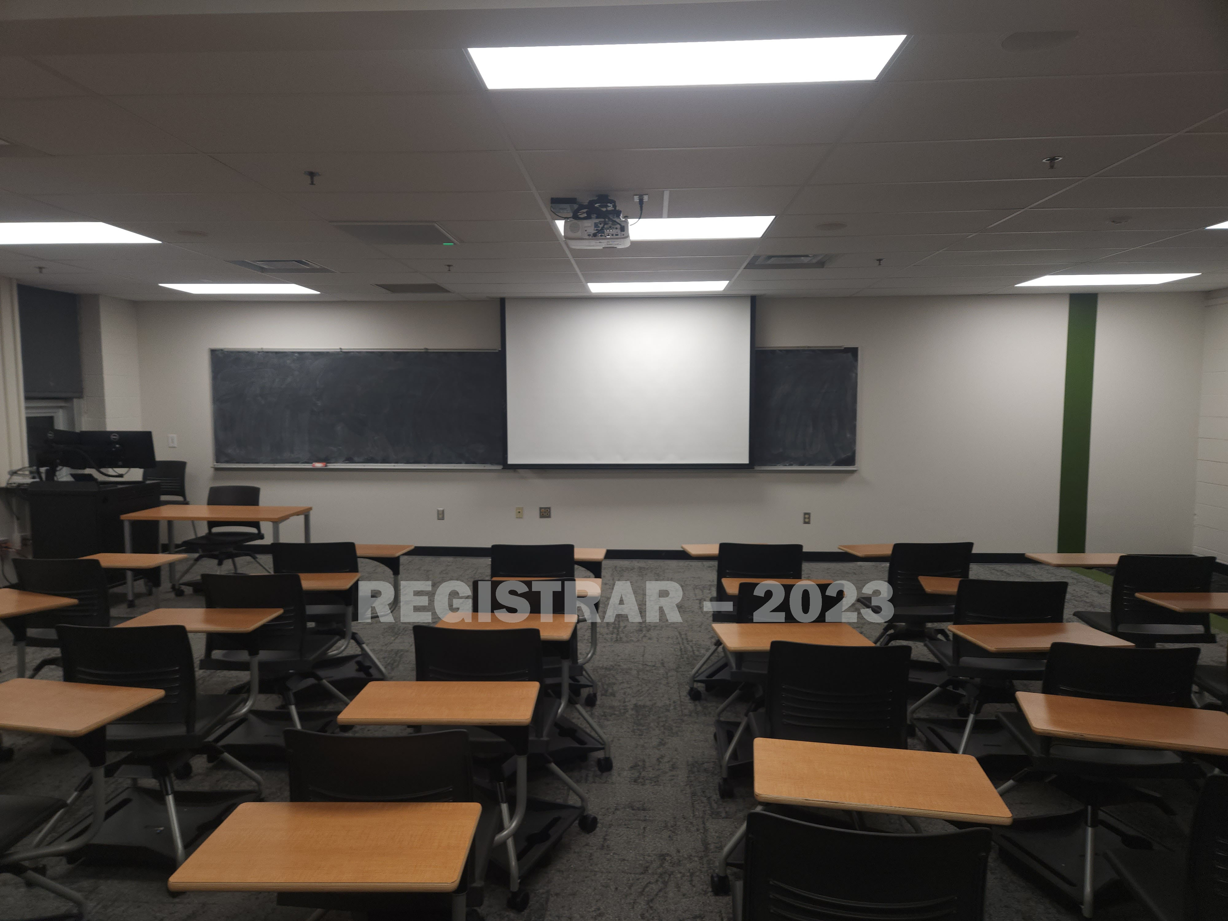 Hopkins Hall room 246 view from the back of the room with projector screen down