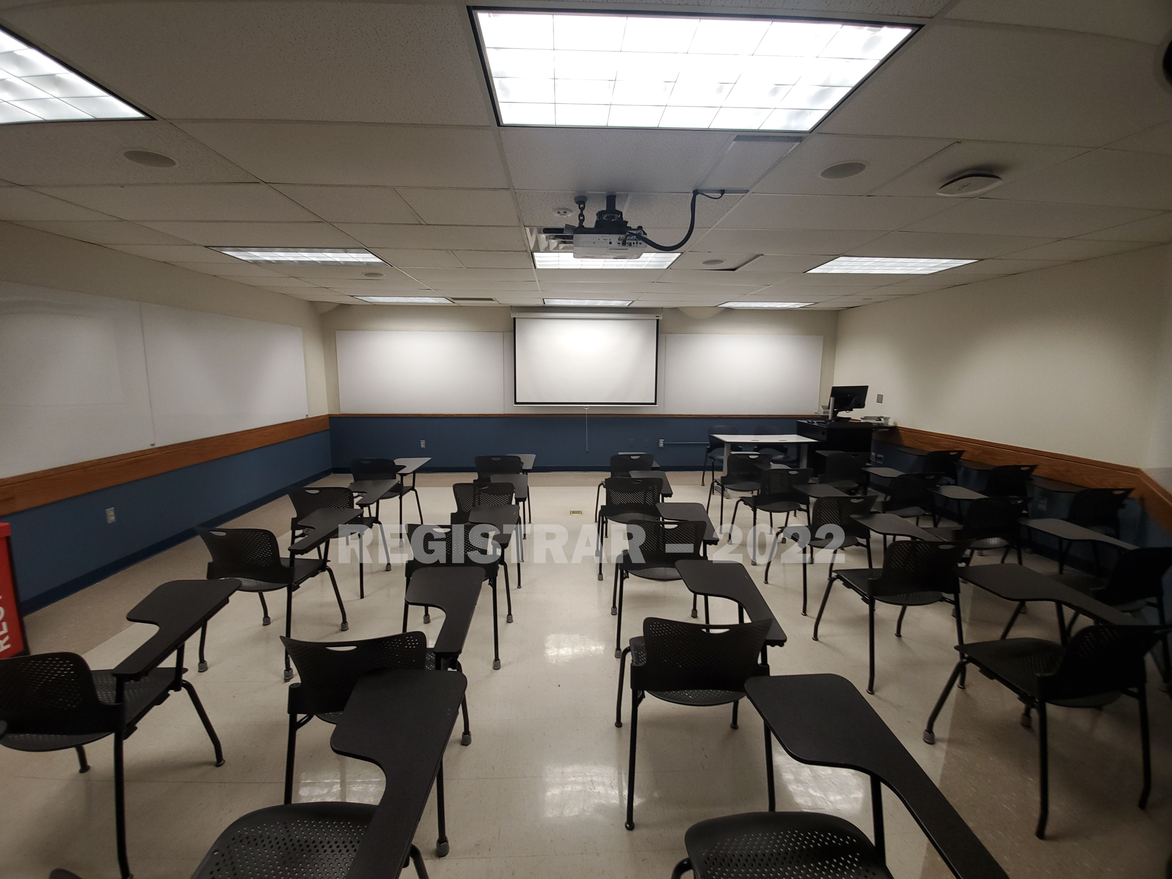 Enarson Classroom Building room 211 ultra wide angle view from the back of the room with projector screen down