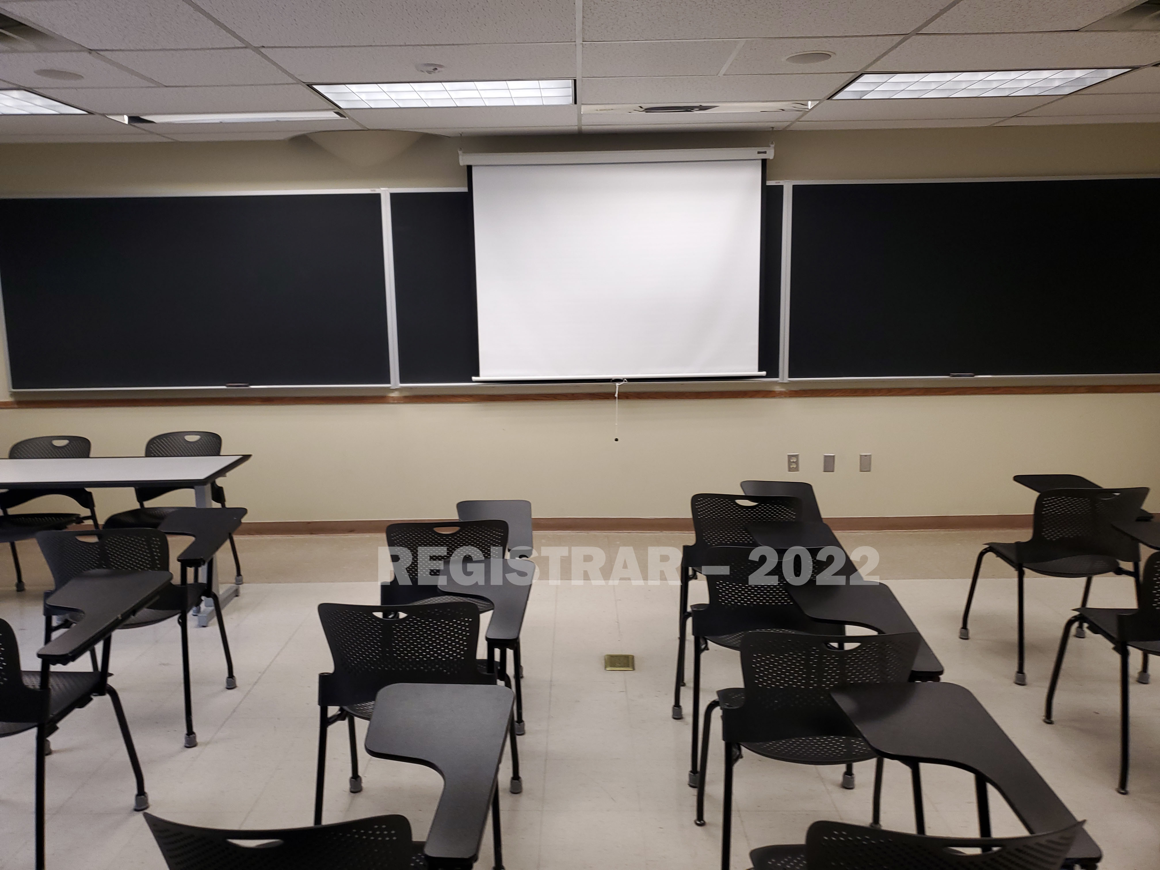 Enarson Classroom Building room 258 view from the back of the room with projector screen down