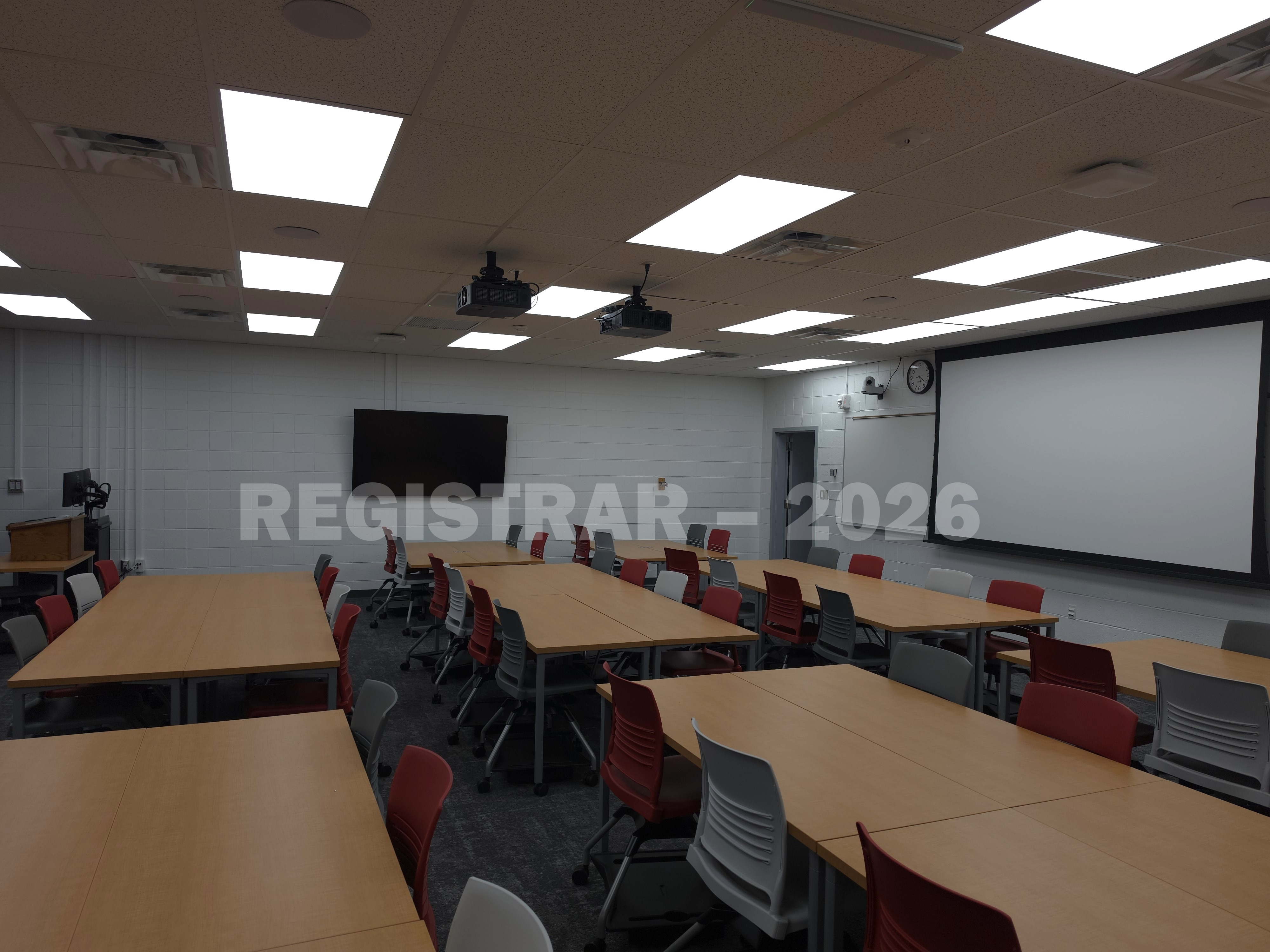 University Hall room 86 view from the back of the room with projector screen down