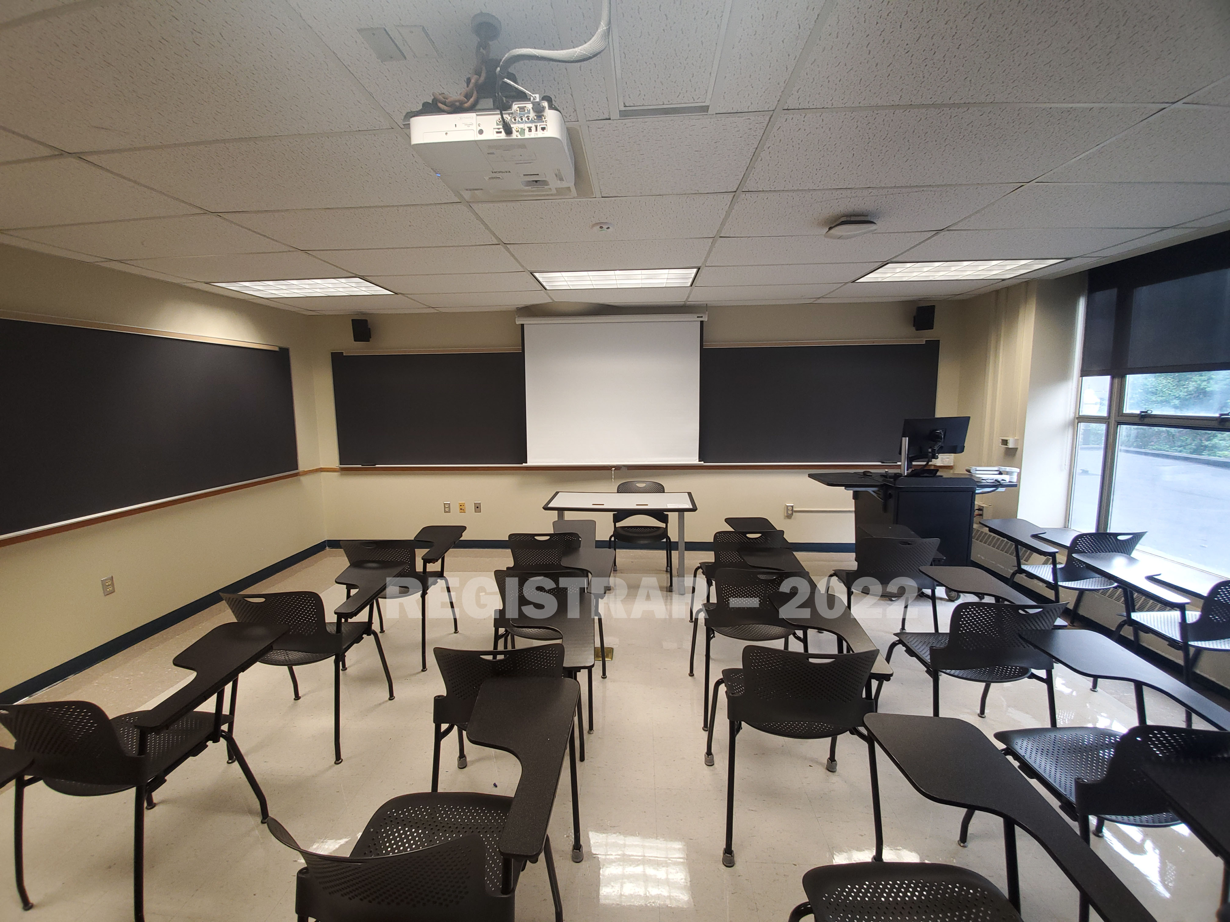 Enarson Classroom Building room 214 ultra wide angle view from the back of the room with projector screen down