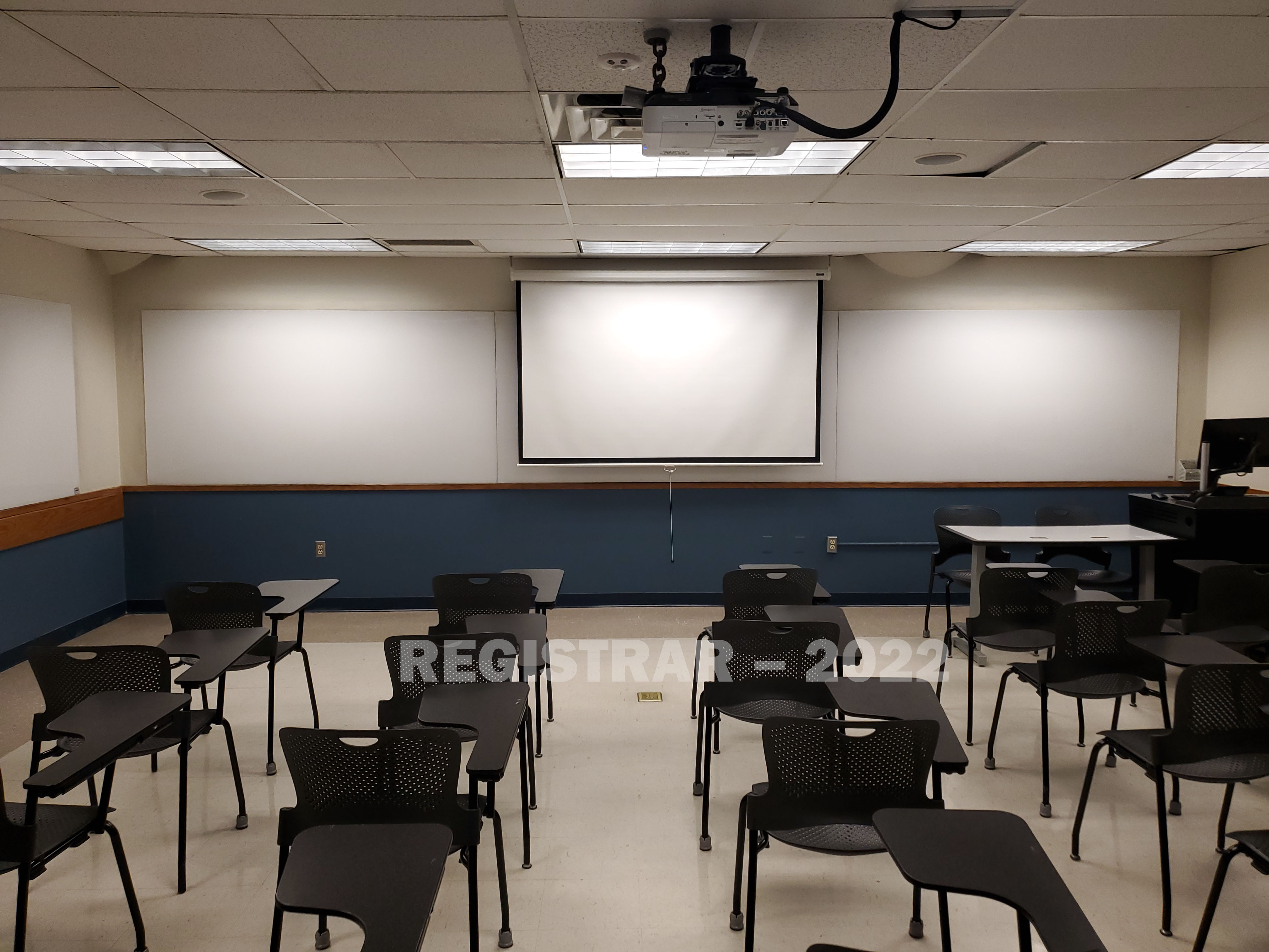 Enarson Classroom Building room 211 view from the back of the room with projector screen down