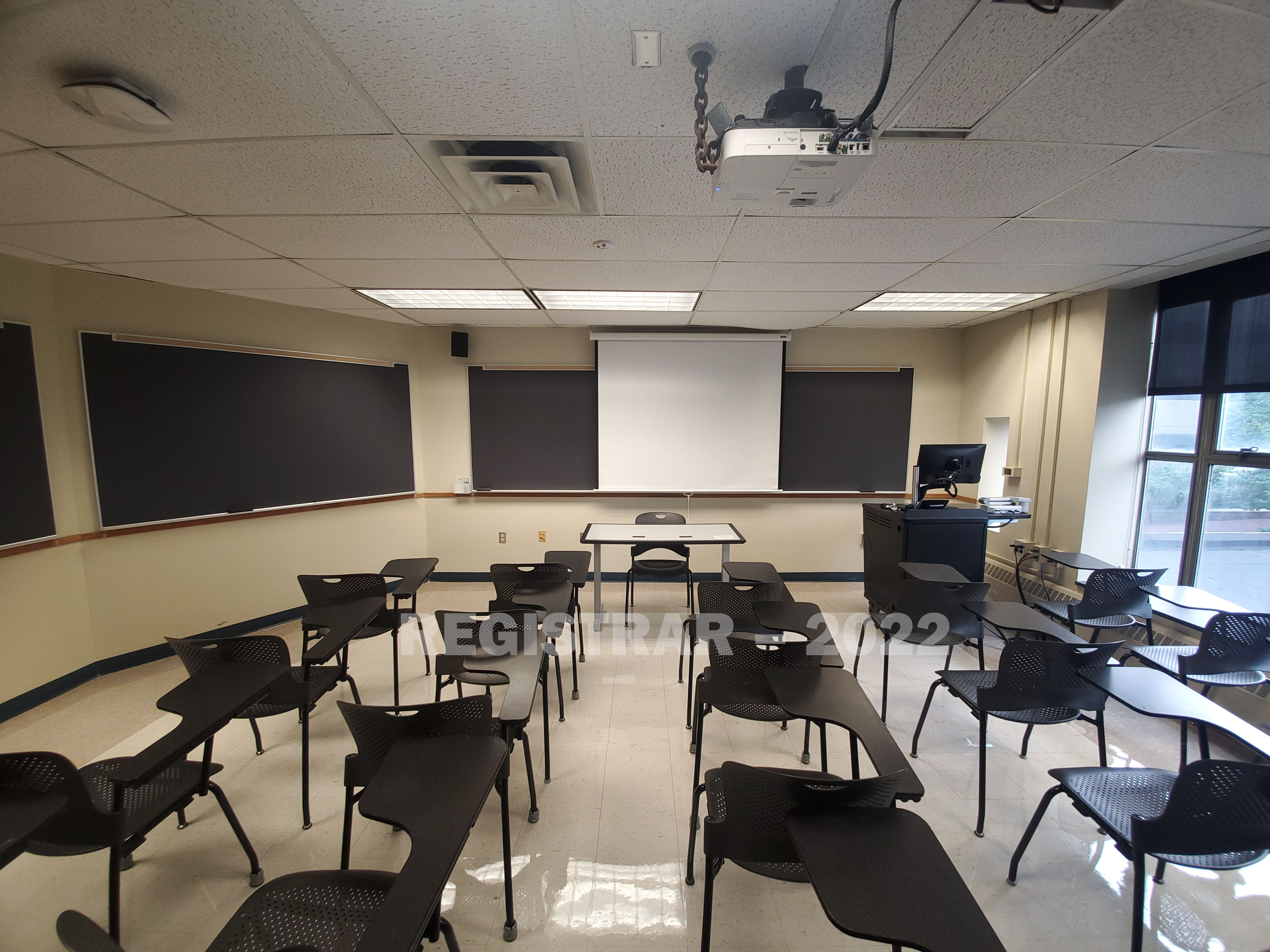 Enarson Classroom Building room 218 ultra wide angle view from the back of the room with projector screen down