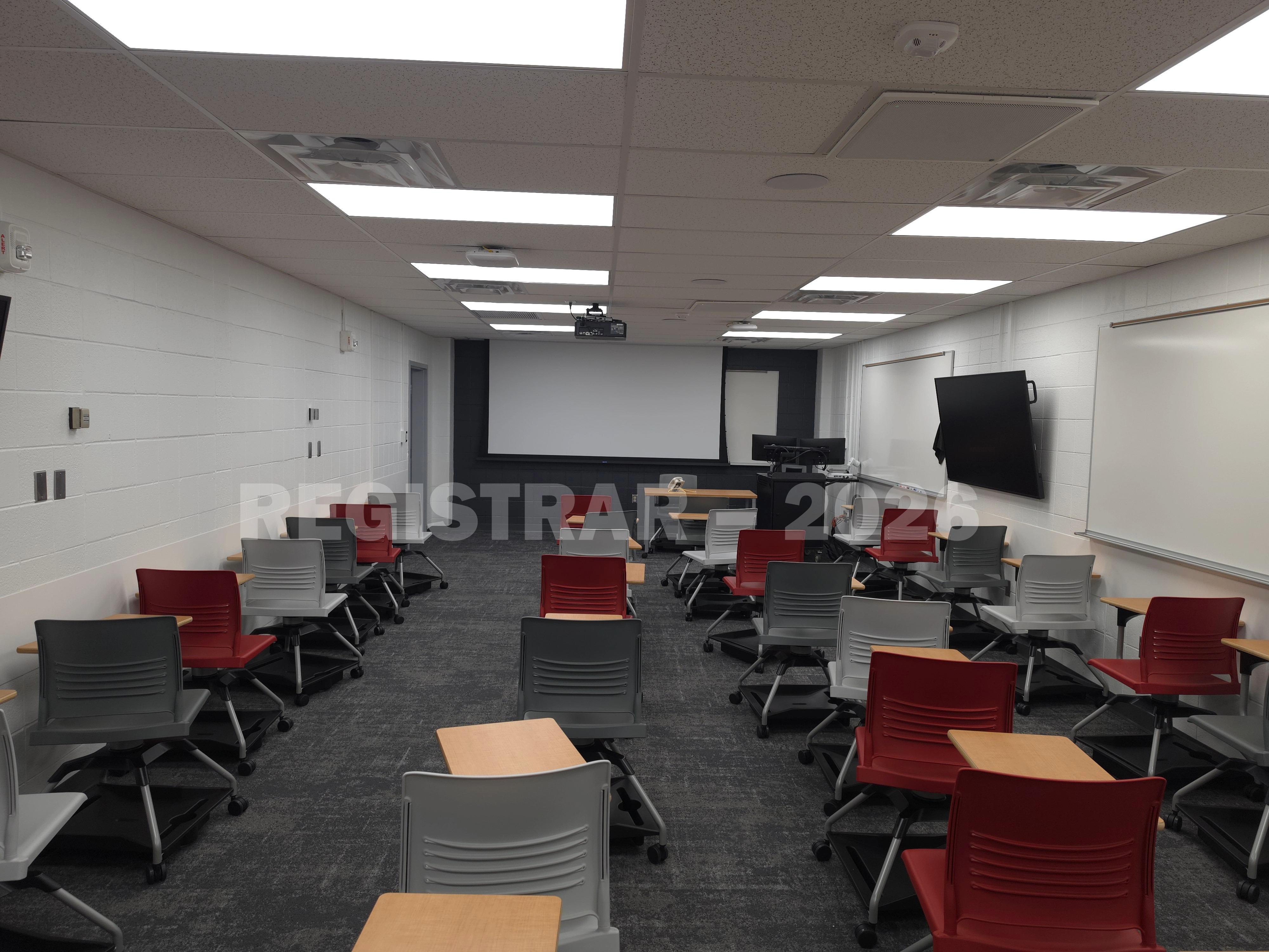 University Hall room 66 view from the back of the room with projector screen down