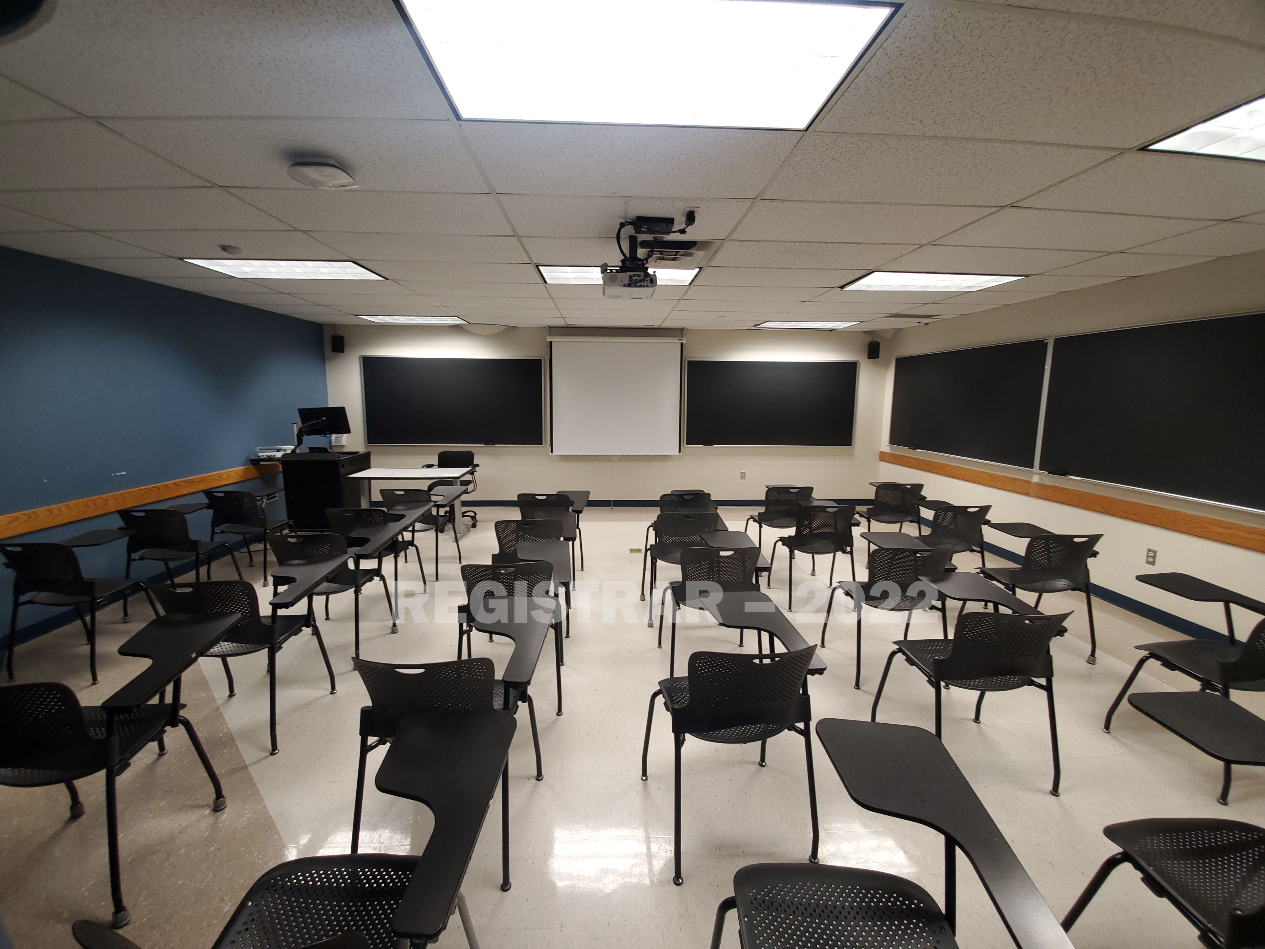Enarson Classroom Building room 243 ultra wide angle view from the back of the room with projector screen down
