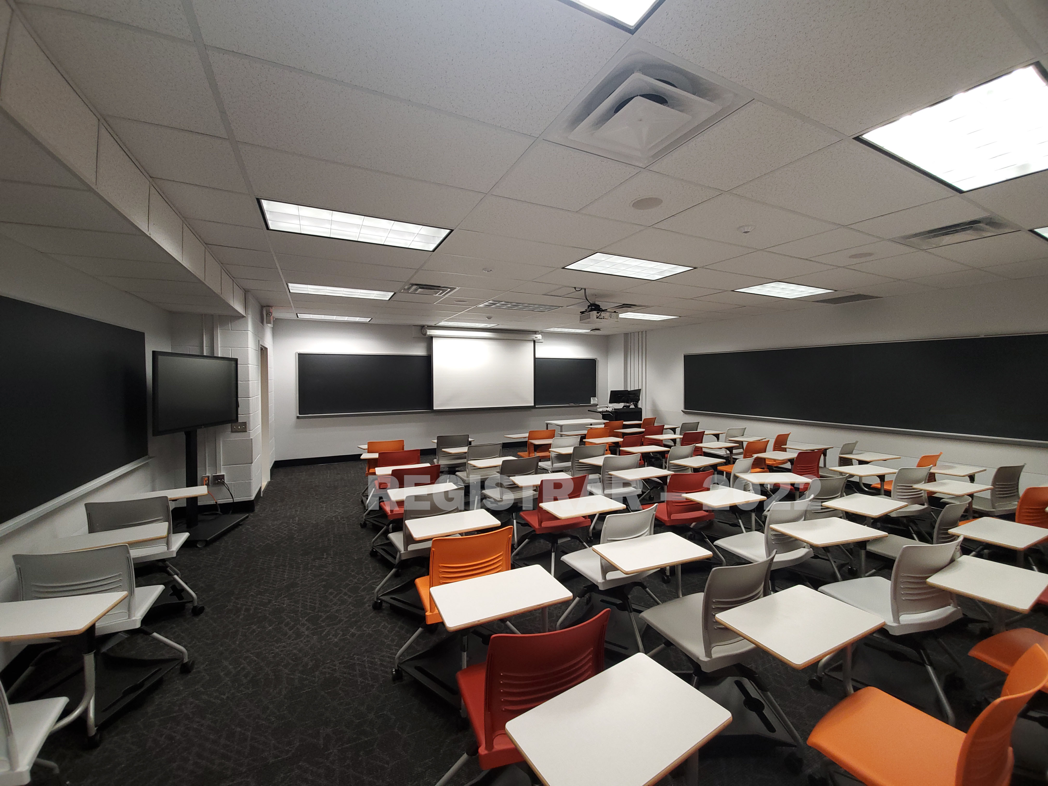Journalism Building room 239 ultra wide angle view from the back of the room with projector screen down