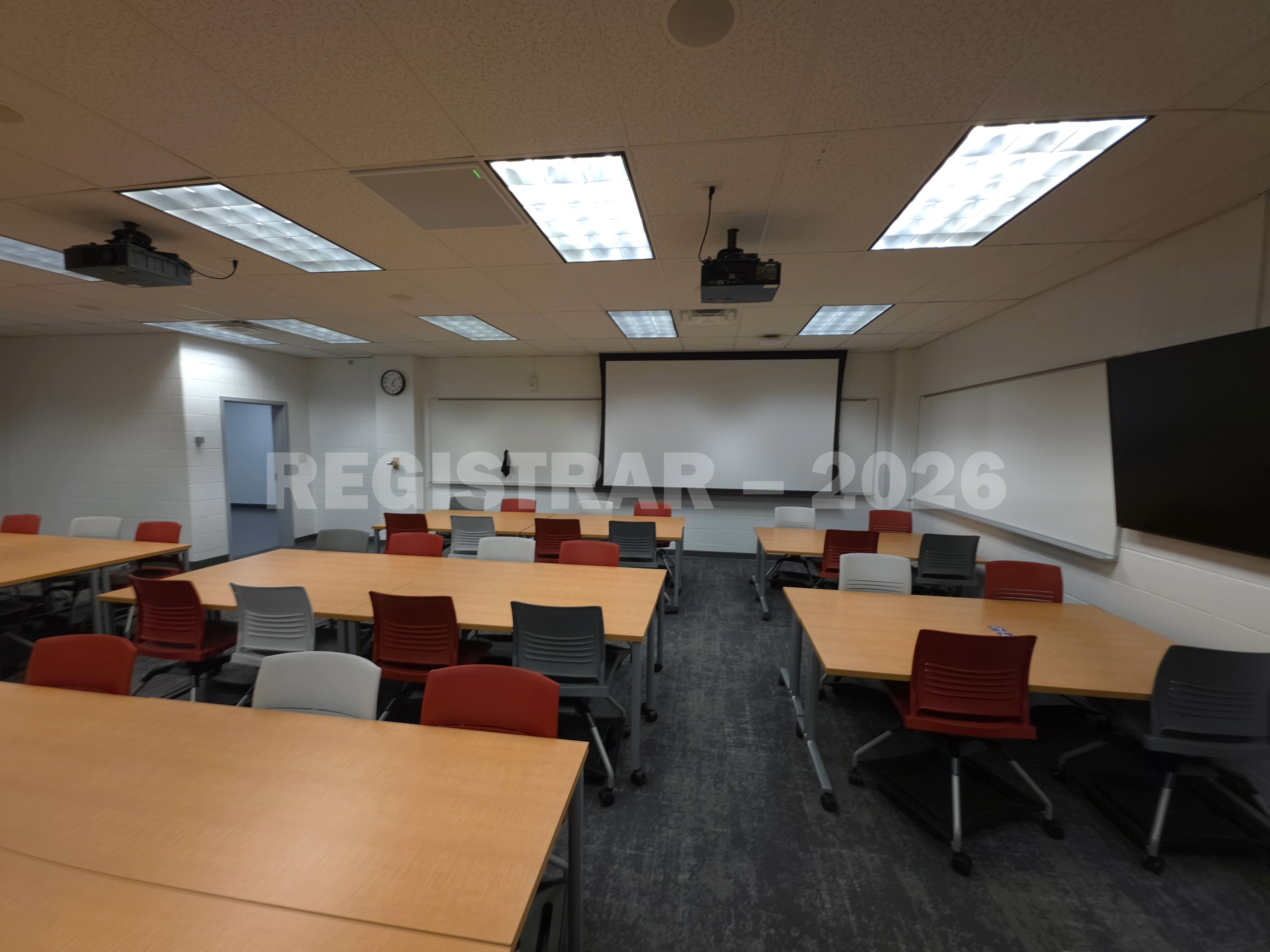 University Hall room 56 ultra wide angle view from the back of the room with projector screen down