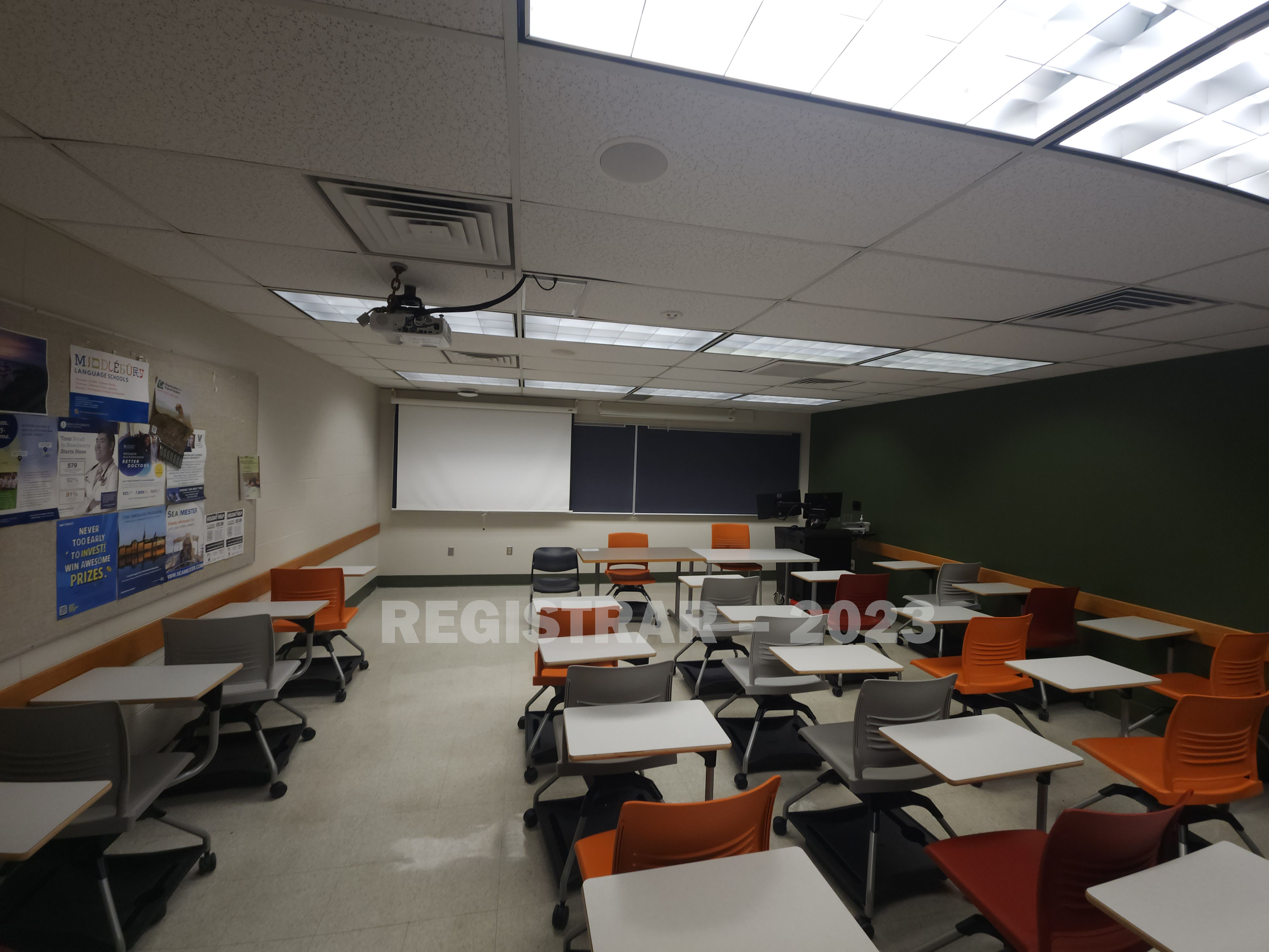 Journalism Building room 221 ultra wide angle view from the back of the room with projector screen down