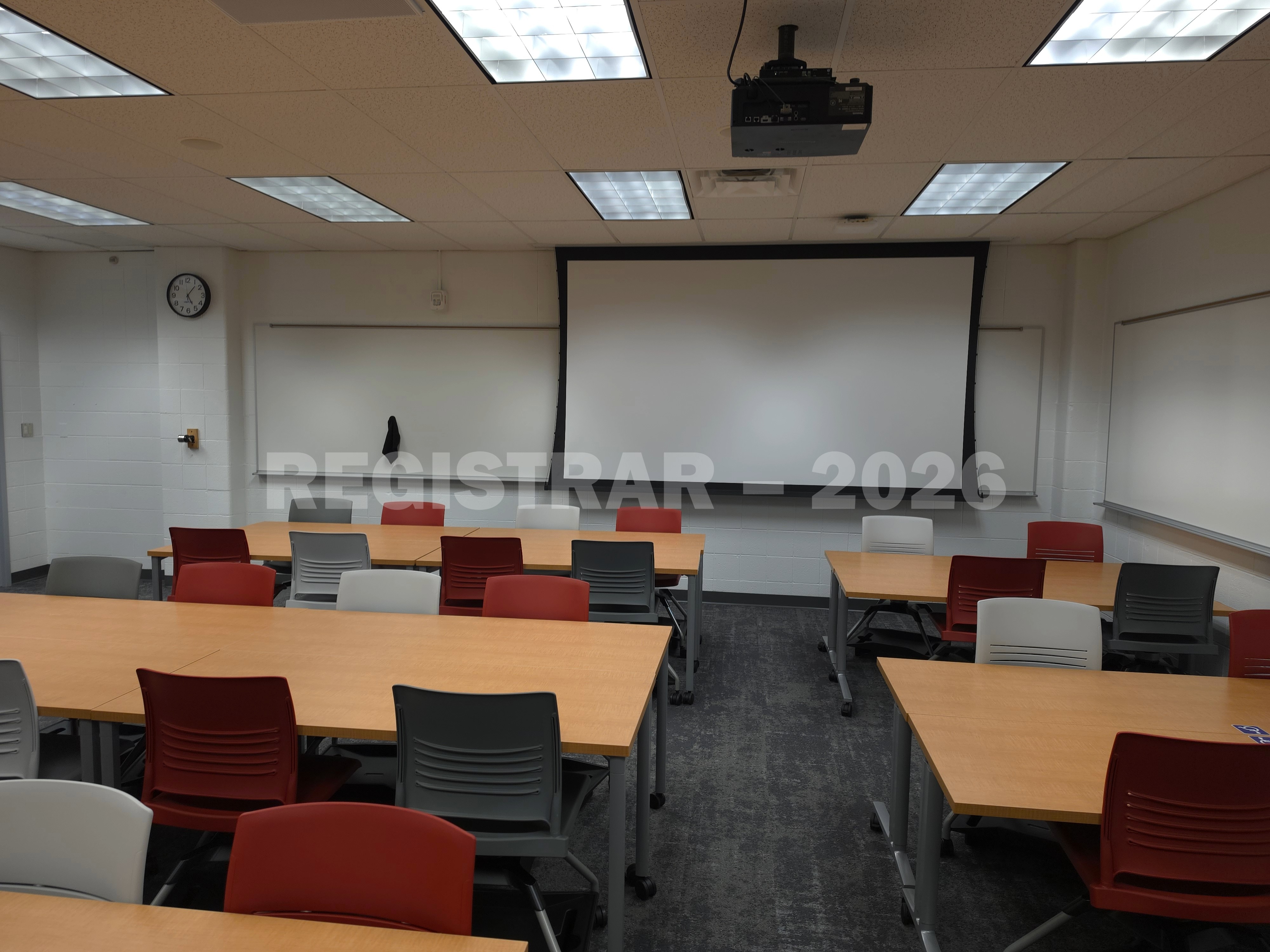 University Hall room 56 view from the back of the room with projector screen down