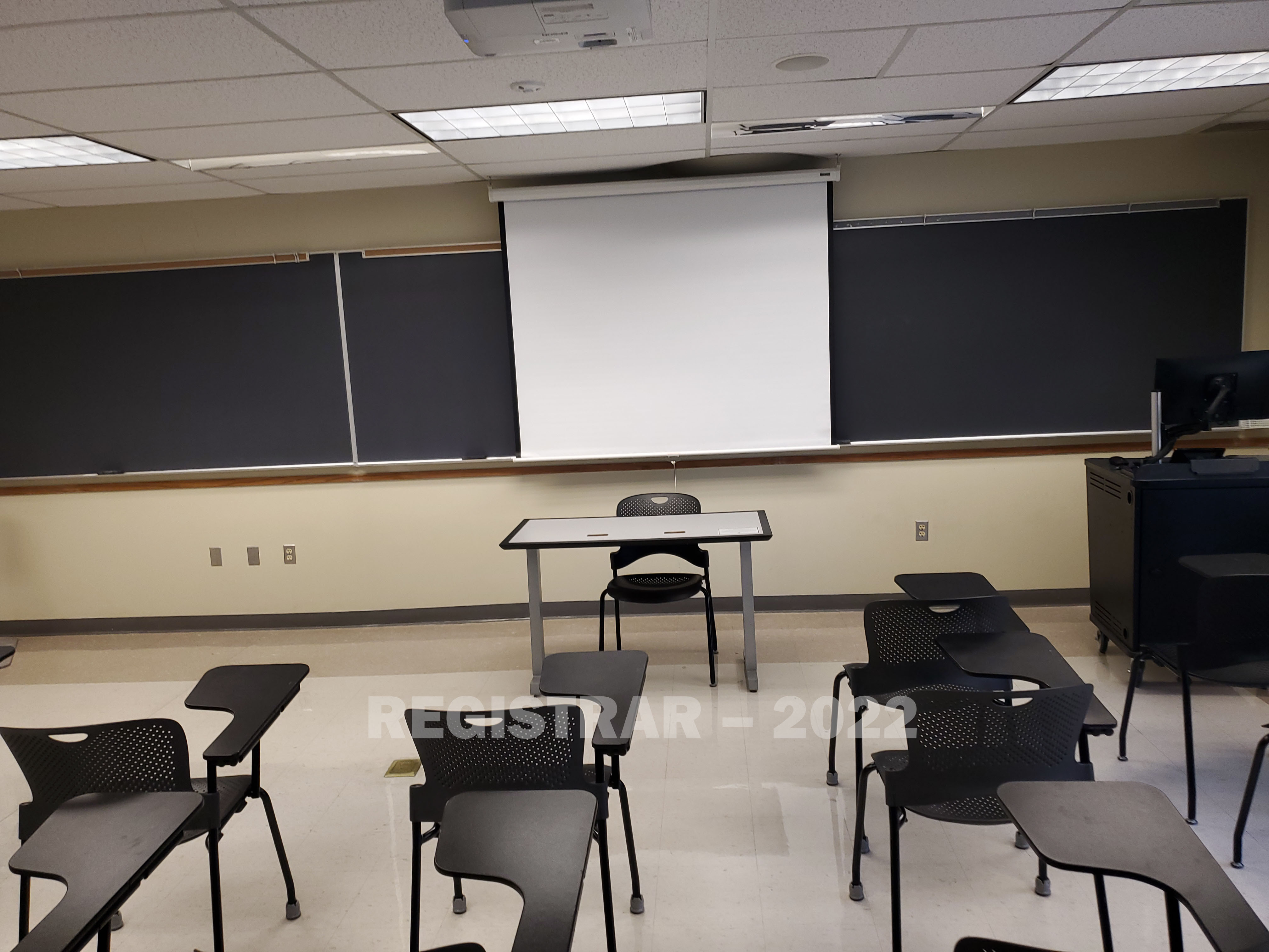 Enarson Classroom Building room 254 view from the back of the room with projector screen down