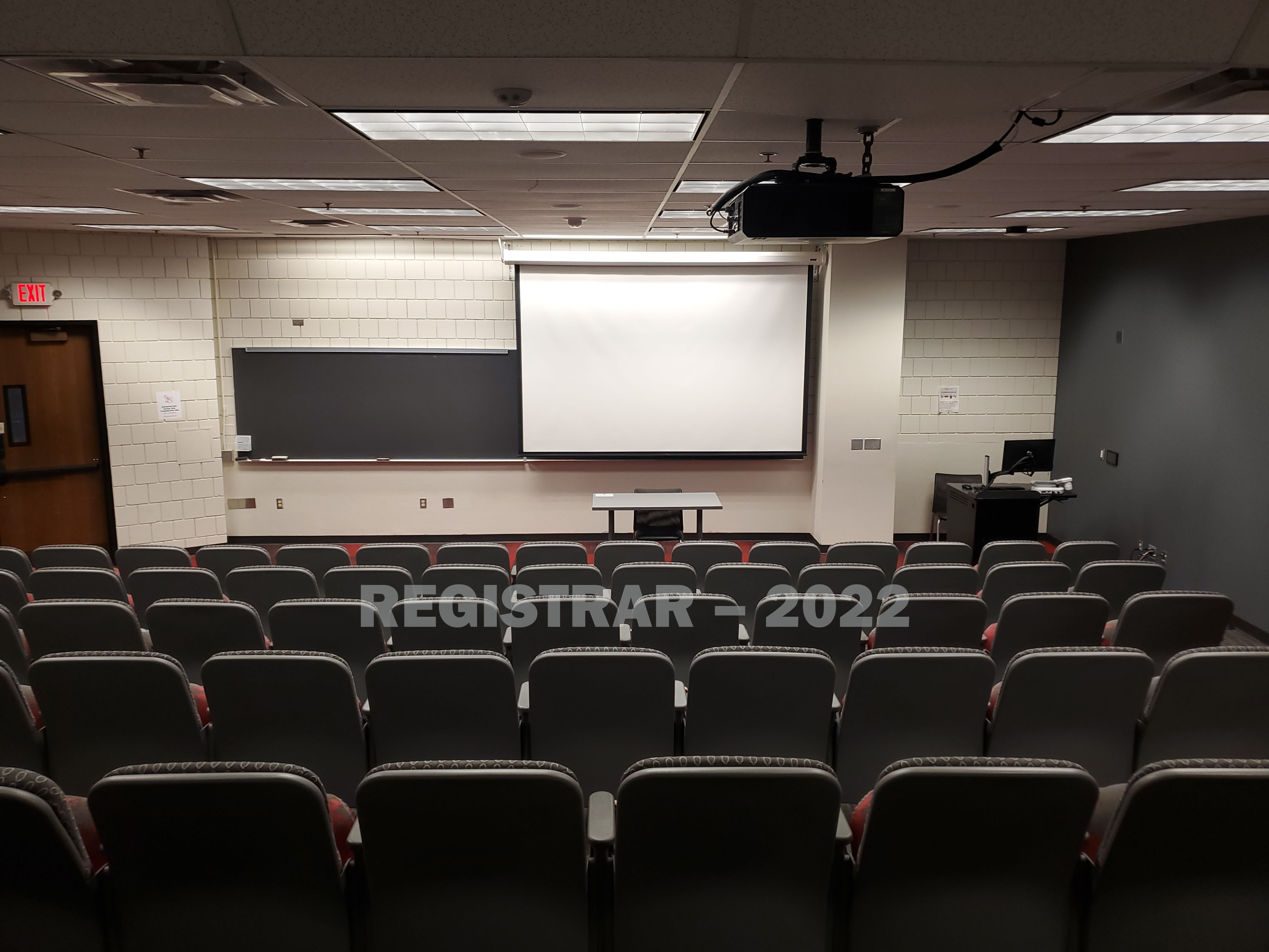Kottman Hall room 104 view from the back of the room with projector screen down
