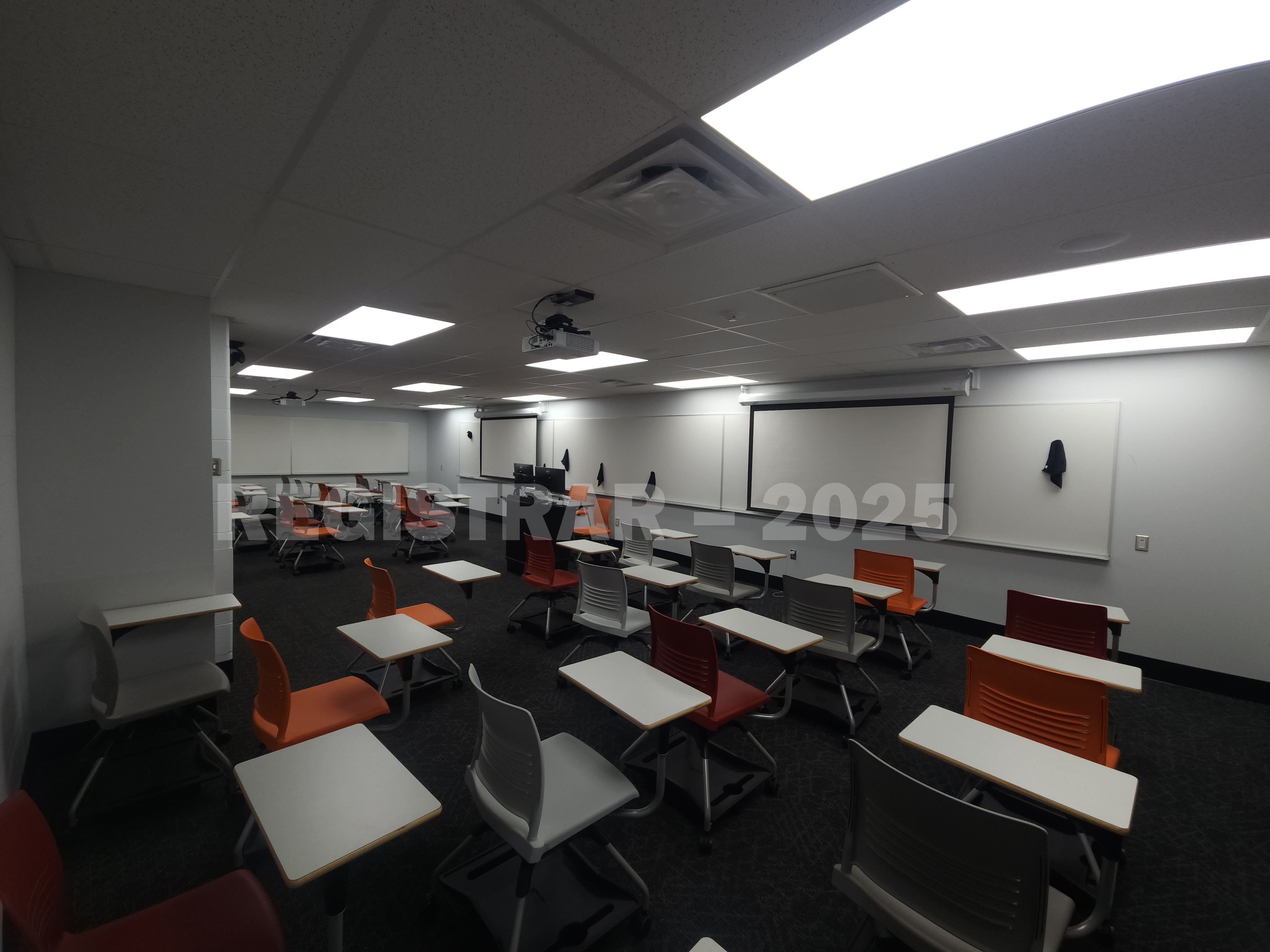 Journalism Building room 221 ultra wide angle view from the back of the room with projector screen down