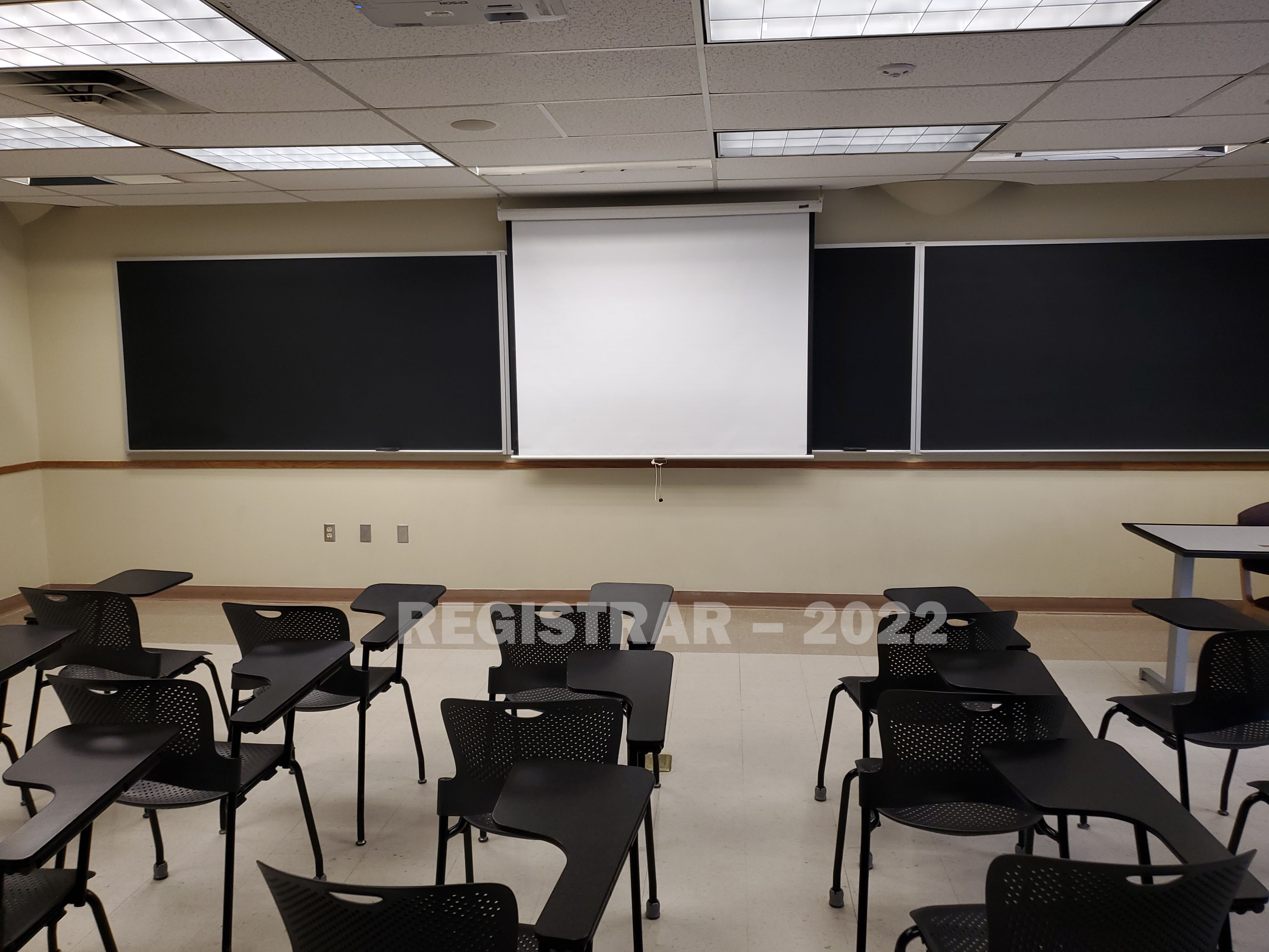 Enarson Classroom Building room 226 view from the back of the room with projector screen down