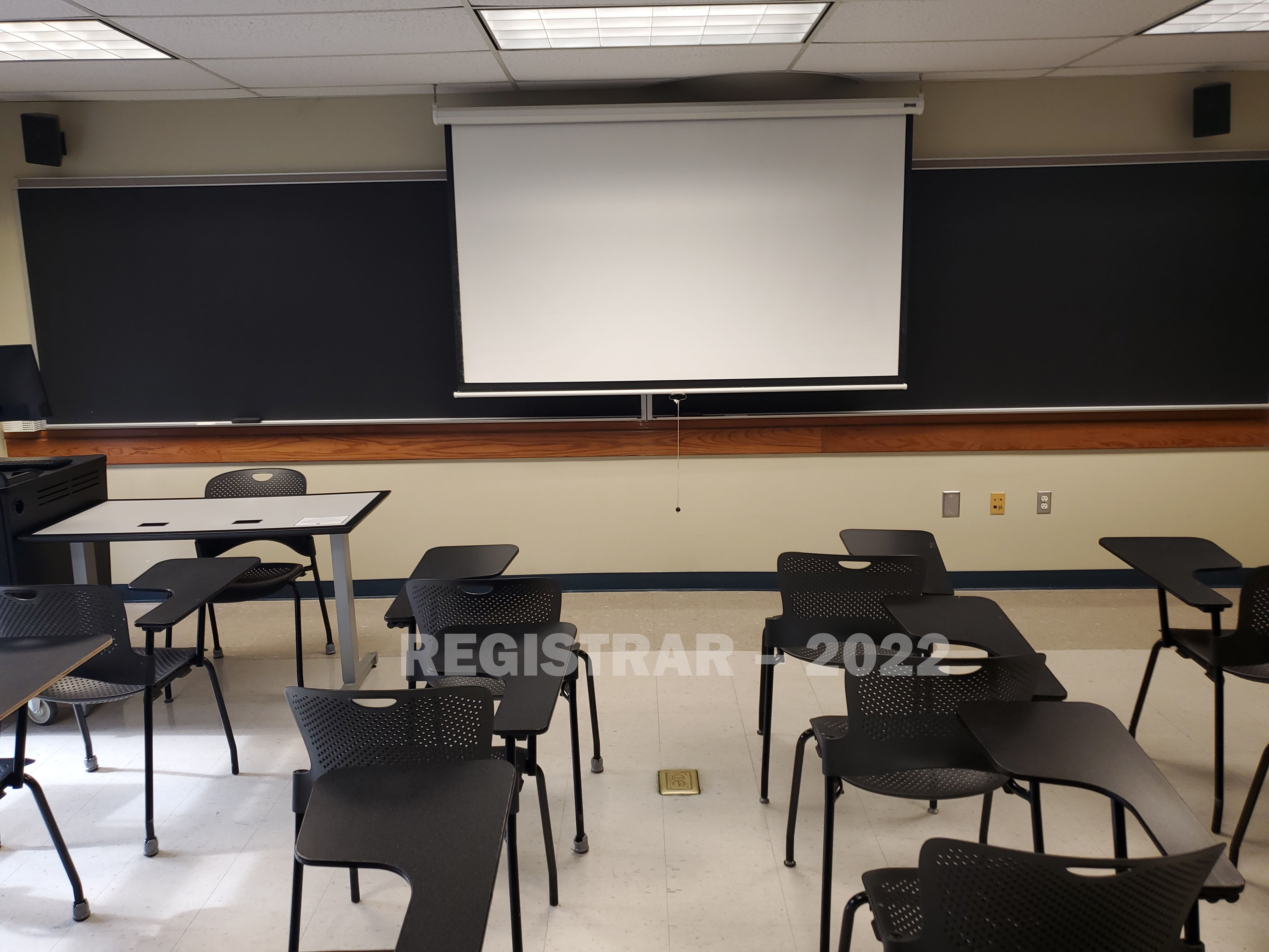 Enarson Classroom Building room 204 view from the back of the room with projector screen down